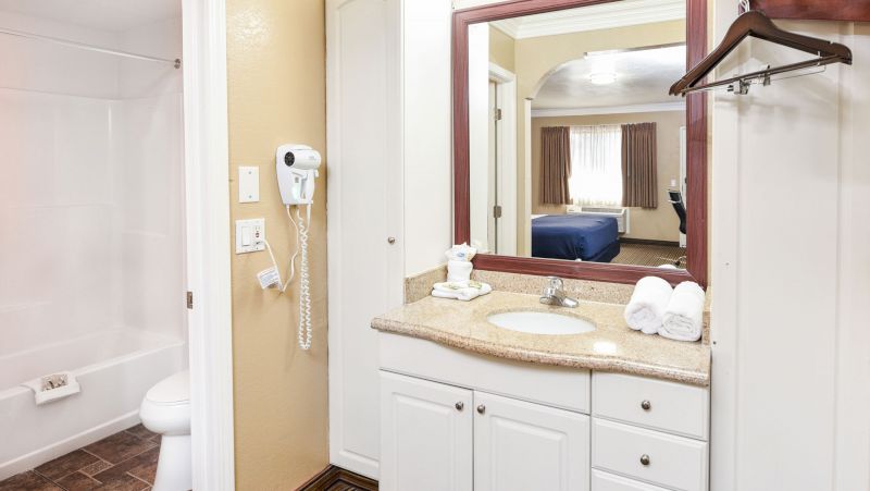 A bathroom with a sink, mirror, and towels